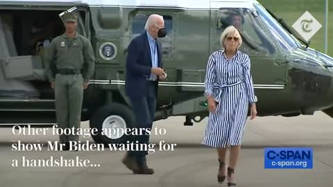 Joe Biden struggles to get his jacket on before dropping his sunglasses