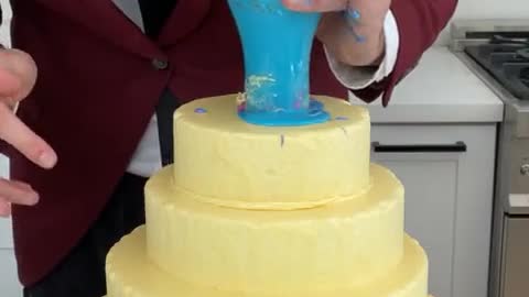 The icing dumps down each layer of the cake perfectly when he lifts the cup!