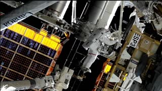Astronauts install rollout solar array outside the space station