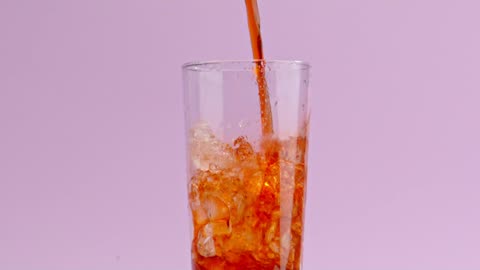 A stream of soda fills up a crystal glass