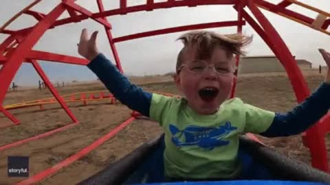 The boy's pure joy as he rides a roller coaster for the first time!