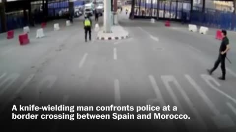 Spanish police throw traffic barrier at knife-wielding man