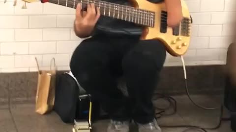 Man with one hand blue shirt playing guitar