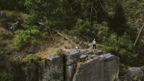 Woman Standing at Edge of Cliff