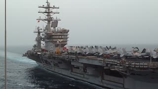 Carrier IKE underway at sea with jets on flight deck for UNREP with USNS Bighorn MSC ship.