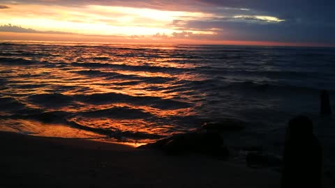 Meditative sea waves during the golden sunset