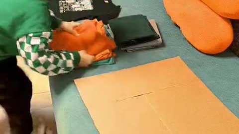 The child used a piece of scrap cardboard to make a quick clothes folding tool