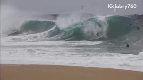 Huge wave knocks down surfers