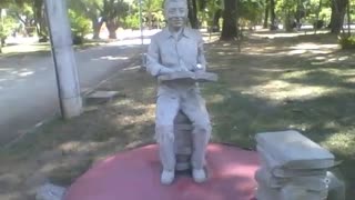 Statue of a man with a book, and several books on the floor closed [Nature & Animals]