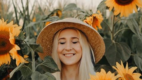 Woman Holding Sunflowers on a Field