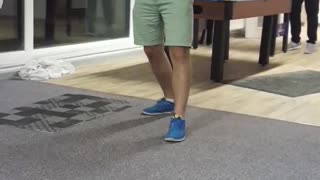 Guy in purple shirt gets dart tossed on his foot