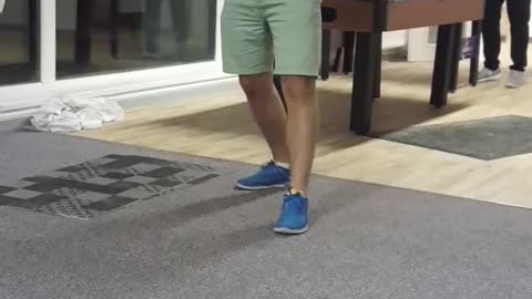 Guy in purple shirt gets dart tossed on his foot