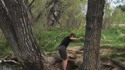 Brown shirt kid fails to clear creek on rope swing