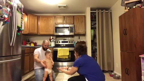 Toddler Photobombs Baby's First Steps
