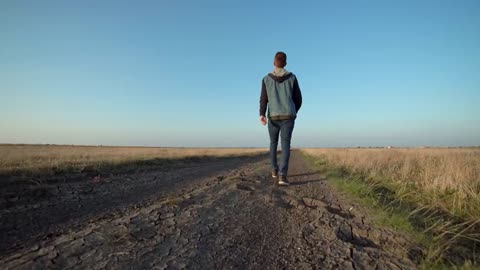 Young man walking in a rural path