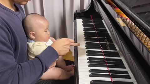 A baby who uses his dad's super-luxury piano as a toy