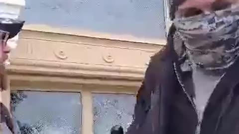 Protester using baton to smash Capitol Window