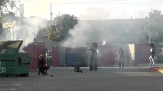 People Taking Pictures in Front of a Burning Dumpster During Protests
