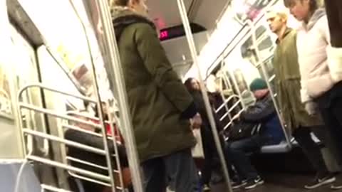 Four passengers stand still on subway train eyes closed