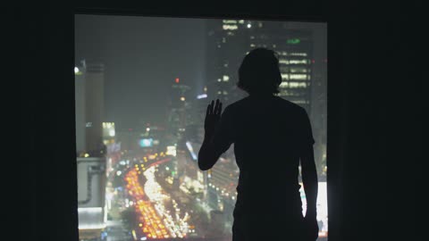 Silhouetted Man Looking Out of Window