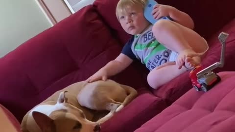 Kid uses flip flop as a phone while petting his doggy friend