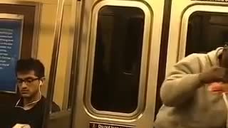 Guy in grey sweatshirt pretends to box on subway