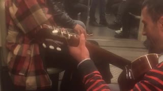 Old sunglasses man sings with guitar on subway