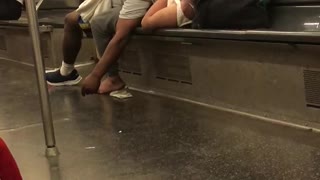 A man asleep on woman on train woman wraps legs