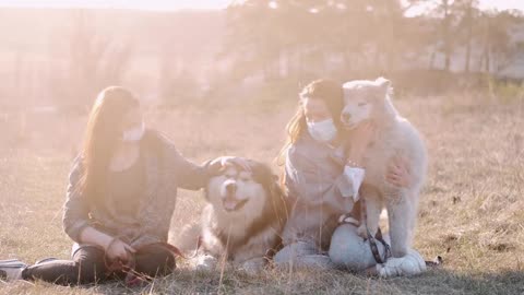 2 women play with dog