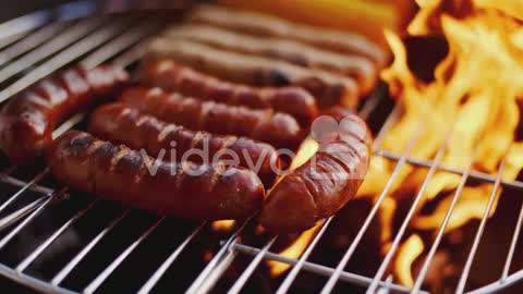 Sausages grilling over the flames