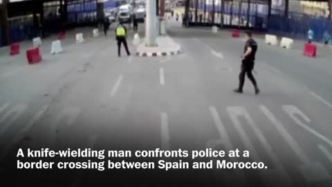 Spanish police throw traffic barrier at knife-wielding man