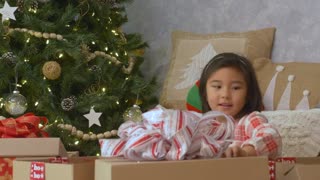A very excited girl opening her Christmas presents