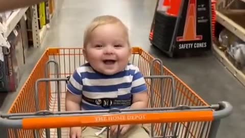 Baby adorable laughing while riding on trolley