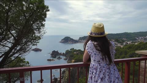 young woman looking at the sea coast on high balcony tossa de mar spain