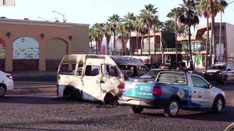 Bullet holes, burned cars in town where Guzman hid