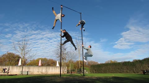 Professional Circus Acrobats Performing Insane Flips And Drops Off A Pole At A Park