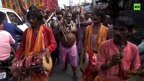 Worshippers parade with snakes honoring Indian Snake God Shesha Nag