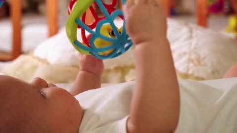 Little baby playing with toys on his bed