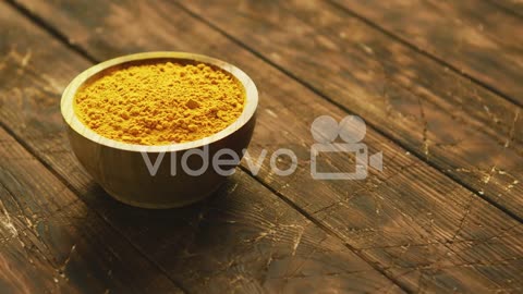 Small bowl of orange turmeric spice