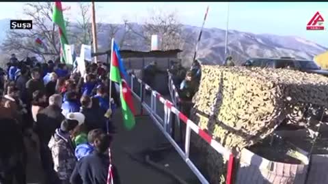 Azeri protesters allow a Russian peacekeeping mission truck through the corridor