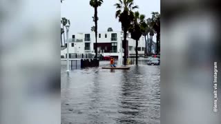 Man paddles through flooded San Diego street