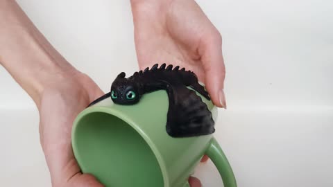 Night Fury Toothless Beamy Eyes How to Train Your Dragon sit on a green cup. Mug with a black dragon