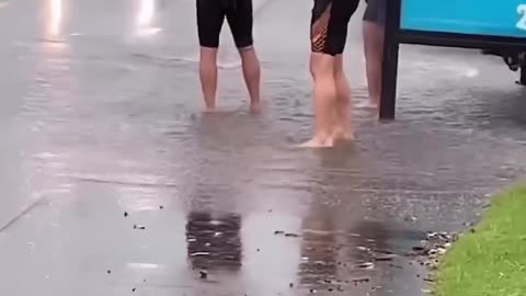Men Wait For Cars To Splash Them