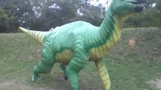 Escultura de um dinossauro verde e amarelo no museu de ciências [Nature & Animals]