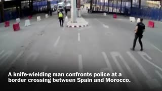 Spanish police throw traffic barrier at knife-wielding man