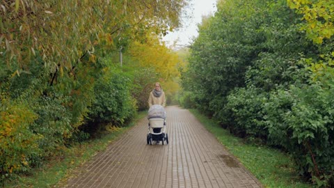 Mother and baby walking through a city park