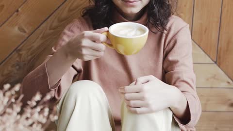 Young Woman Smiling and Drinking Coffee