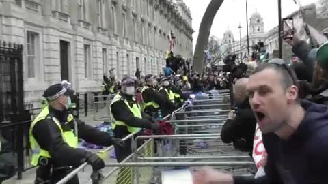 A MEMBER OF THE NHS THROWS THEIR ID CARD AT THE GATES OF DOWNING STREET