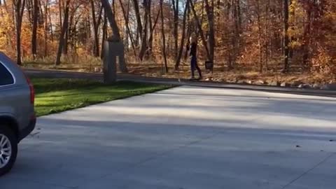 Skateboarding girl in black shirt falls on driveway