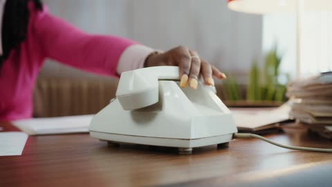 A Female Person Answering a Telephone